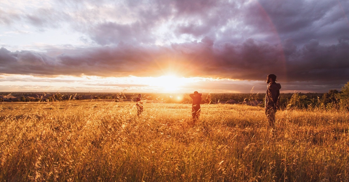 People in Meadow at Sunset